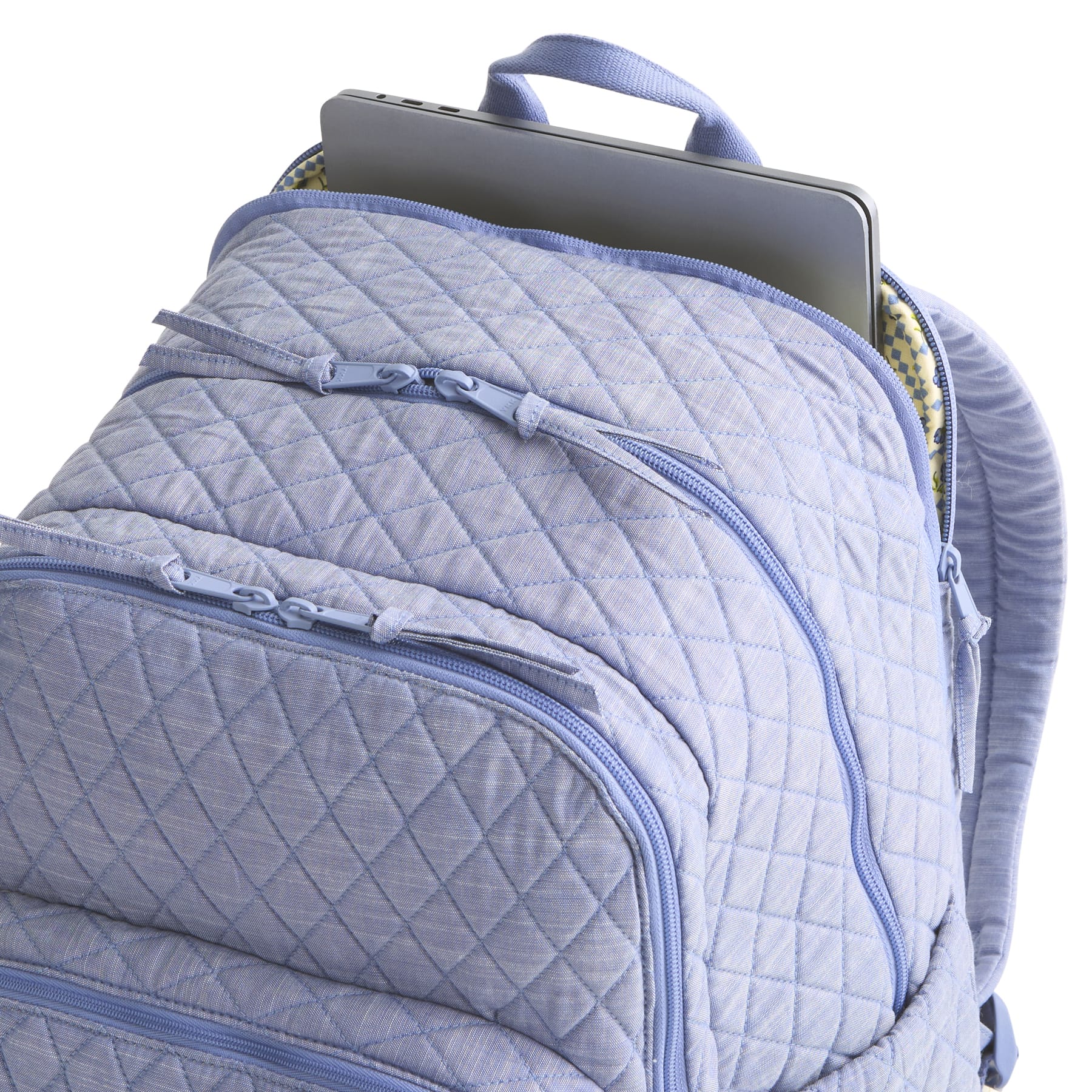 Quilted blue backpack with a laptop inside on a white background