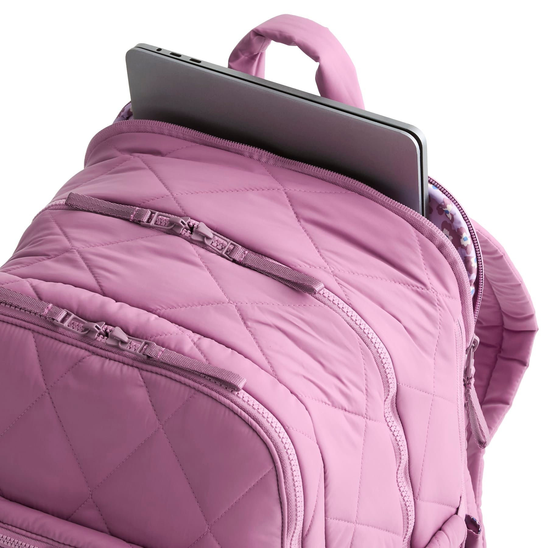 Purple backpack with a laptop inside on a white background
