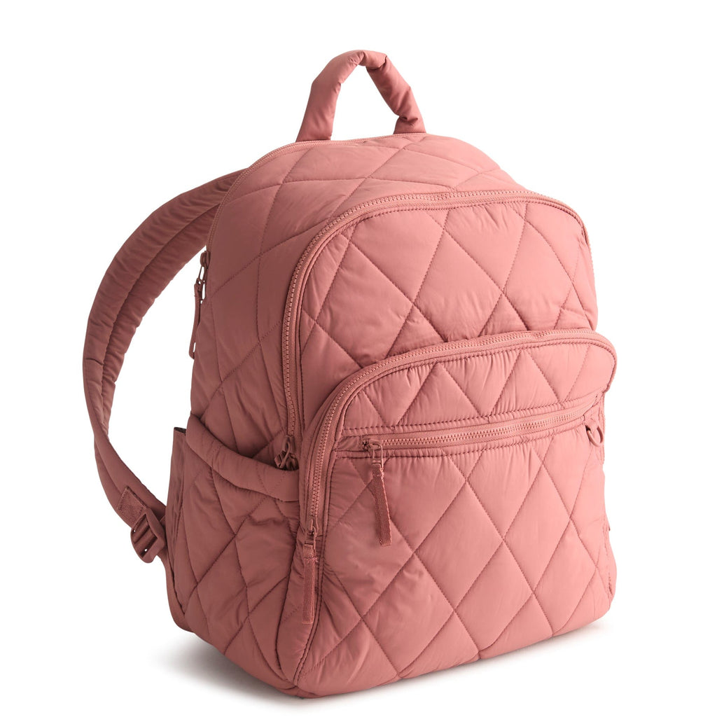 Pink quilted backpack on a white background