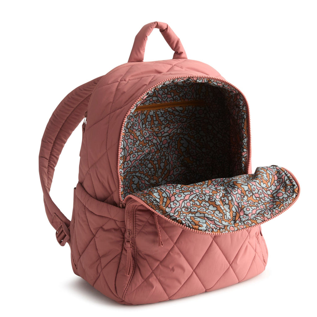Pink quilted backpack with floral interior on a white background