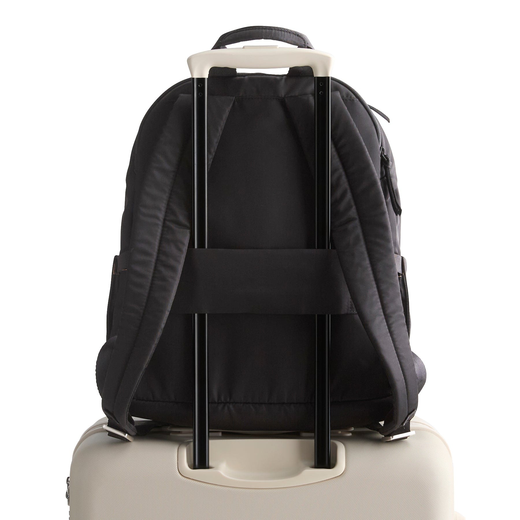 Black backpack with wheels attached to a beige suitcase on a white background