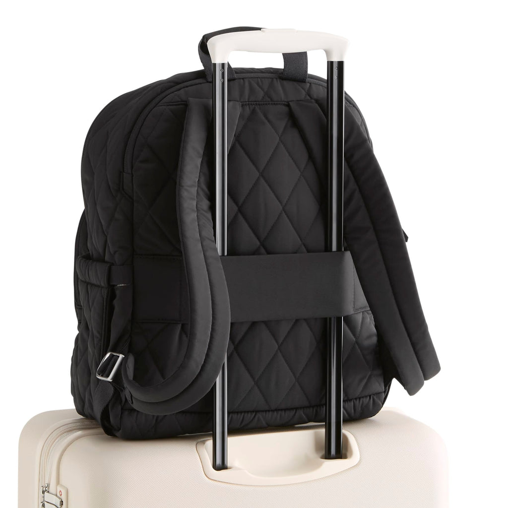 Black quilted backpack with a white handle on a white background