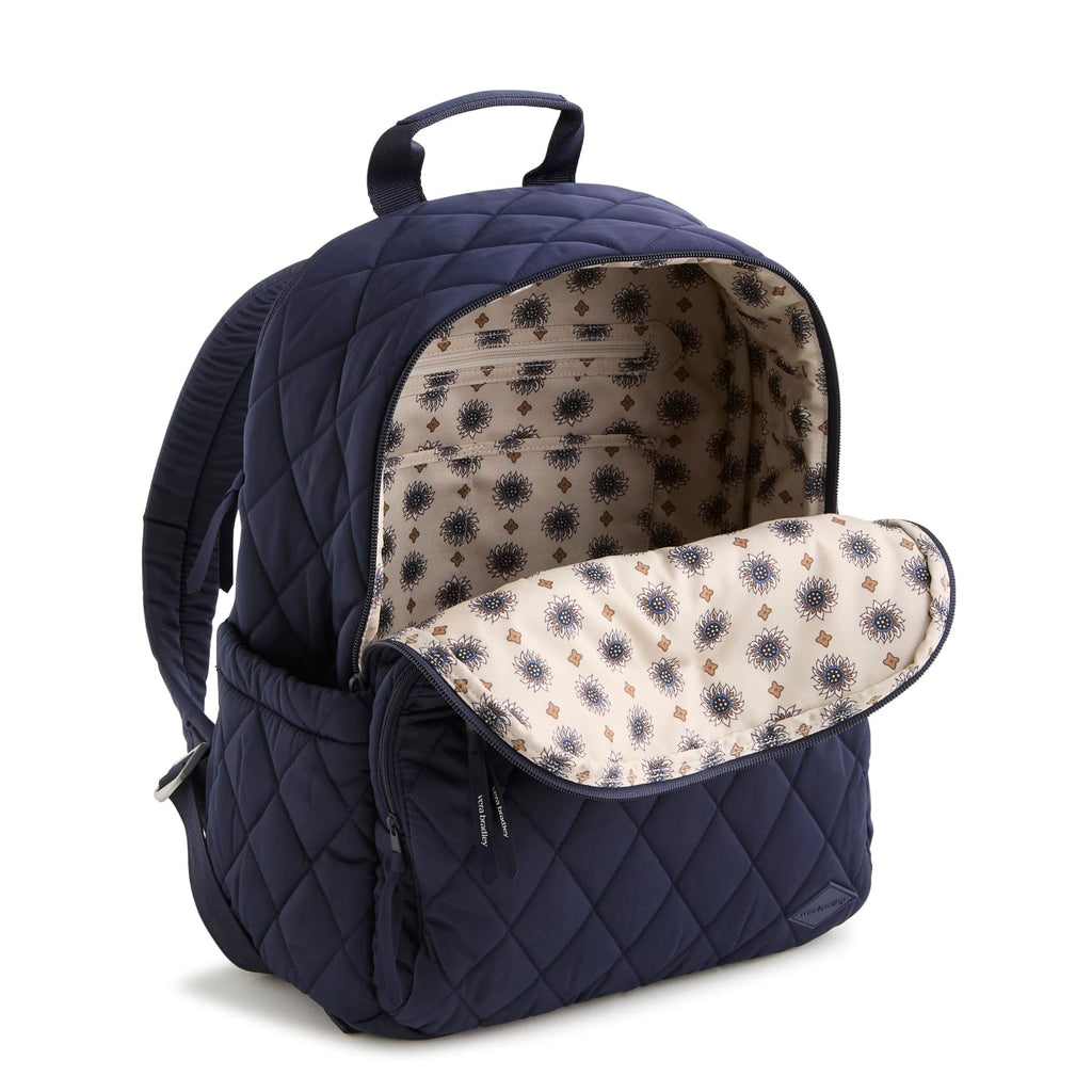 Navy blue quilted backpack with floral patterned interior on a white background