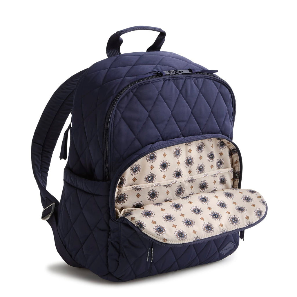 Navy blue quilted backpack with floral interior lining on a white background